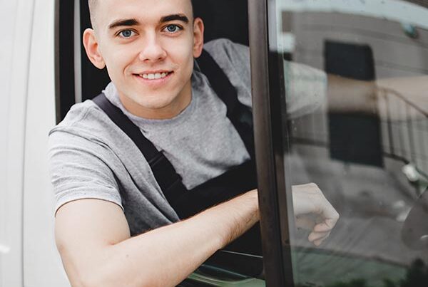 Young van driver leaning out of his window, smiling at the camera. Happy he has used Zixty for his temporary van insurance.